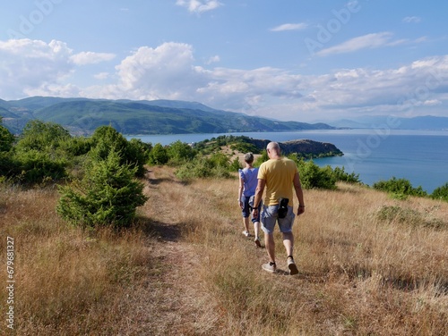 Couple hiking on Lin peninsula, Albania, Lake Ohrid in the background.