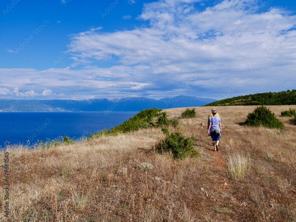 Couple hiking on Lin peninsula, Albania, Lake Ohrid in the background.