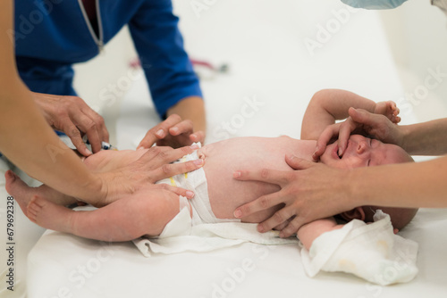 Baby beeing vaccinated by pediatrician in presence of his mother. Preventive vaccination against Diphtheria, whooping cough, tetanus, hepatitis, haemophilus influenzae, pneumococcus, poliomyelitis. photo