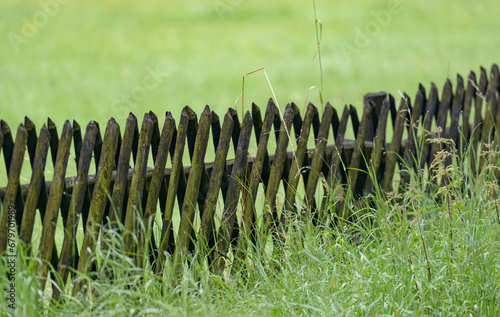 Wooden fence and green grass field in the rural countryside in Germany, Europe