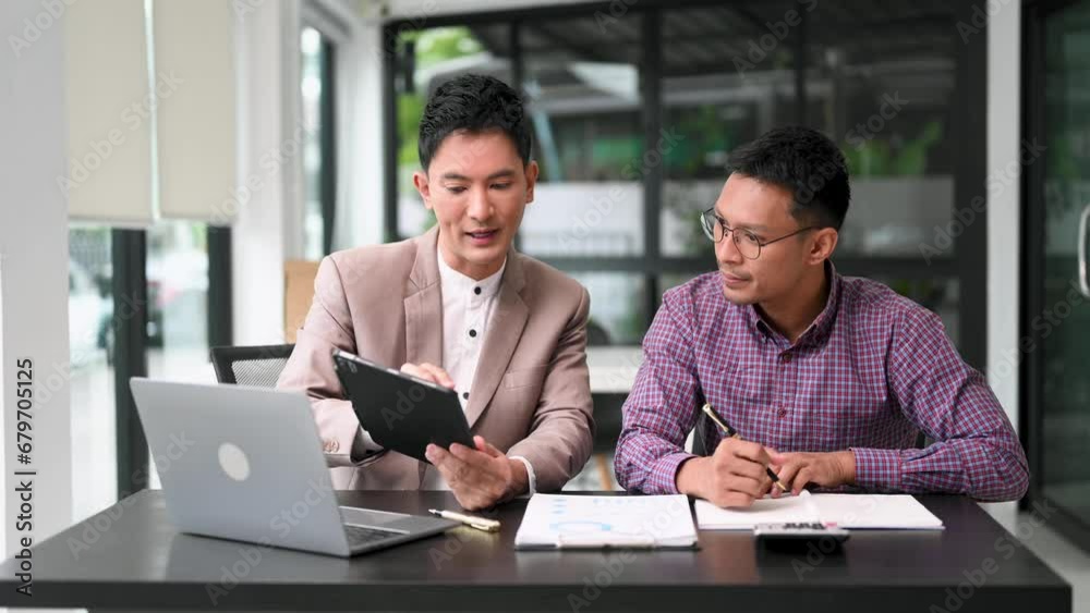 Two business workers talking on the smartphone and using laptop at the office. Two business workers talking on the smartphone and using laptop at the office.