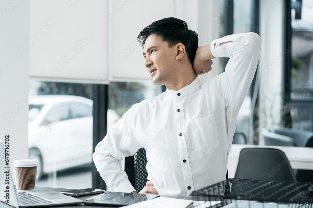 Male businessman is doing a stretchy posture due to sitting in the office for too long, office syndrome concept. Male businessman is doing a stretchy posture due to sitting in the office for too long, office syndrome concept.