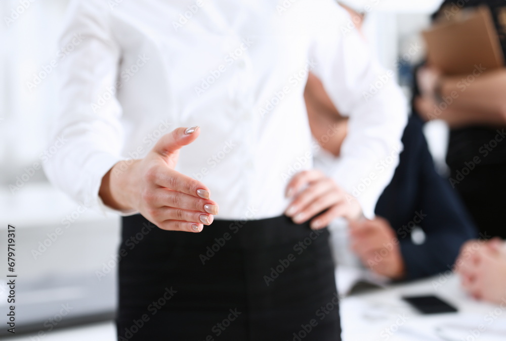 Businesswoman offer hand to shake as hello in office closeup. Serious solution friendly support service excellent prospect introduction or thanks gesture gratitude invite to participate concept