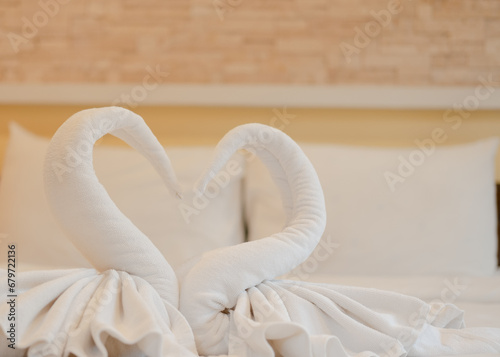White swan-shaped towels on the bed to welcome new guests in a luxury hotel at a seaside resort
