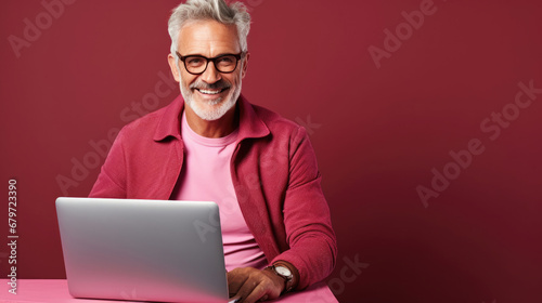 Smiling cheerful smart senior man wearing casual teenage clothes using laptop computer pose looking at camera isolated color background