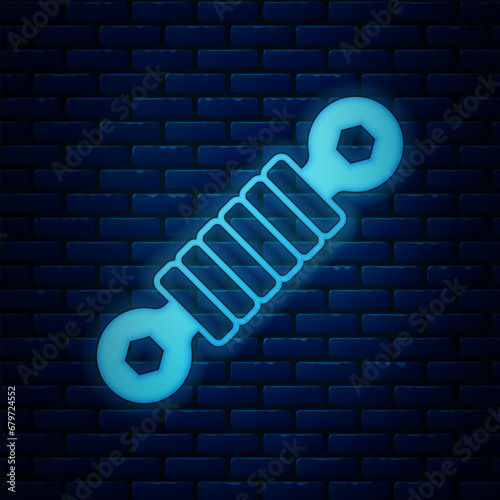 Glowing neon Shock absorber icon isolated on brick wall background. Vector