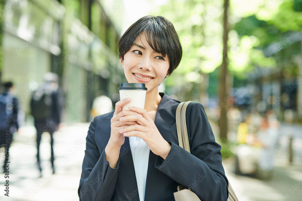 ビジネス街を歩く30代女性会社員,笑顔