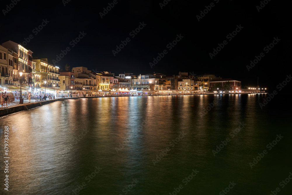Tourists, taverns and houses at night in the port of Chania city, Greece