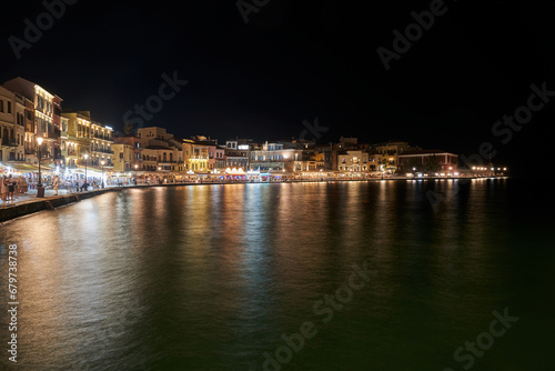 Tourists, taverns and houses at night in the port of Chania city, Greece © GKor