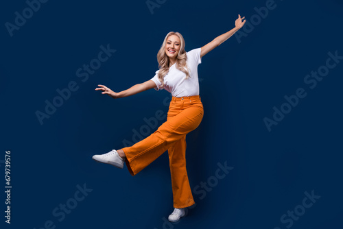 Full length photo of lovely cute positive girl dressed stylish outfit have fun isolated on dark blue color background