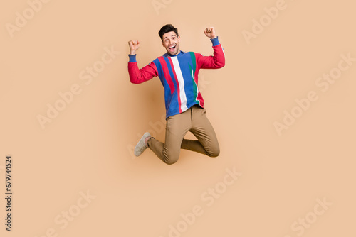 Full length body photo of jumping trampoline funky sportive businessman celebrating finance plan done isolated on beige color background