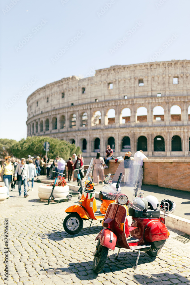 Two Retro scooters stay near the Roman Coliseum. One of the most popular travel place in world, postcard