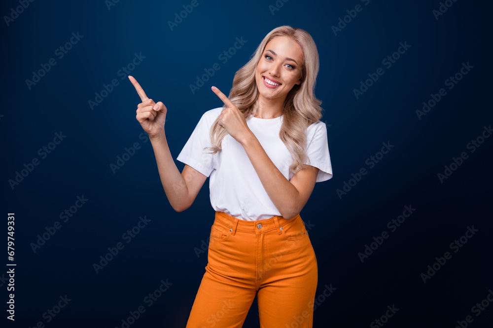 Photo of adorable girl dressed white trendy outfit sharing news special seasonal sale empty space isolated on dark blue color background Photo of adorable girl dressed white trendy outfit sharing news special seasonal sale empty space isolated on dark blue color background
