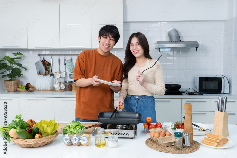 Happy Family portrait of loving young asian of having fun standing a cheerful preparing food and enjoy cook cooking with vegetables, meat, bread while standing on a kitchen Condo life or home Happy Family portrait of loving young asian of having fun standing a cheerful preparing food and enjoy cook cooking with vegetables, meat, bread while standing on a kitchen Condo life or home