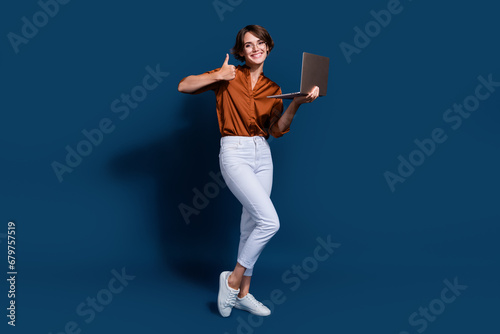 Full length photo of cool confident lady wear brown shirt showing thumb up texting modern gadget isolated blue color background