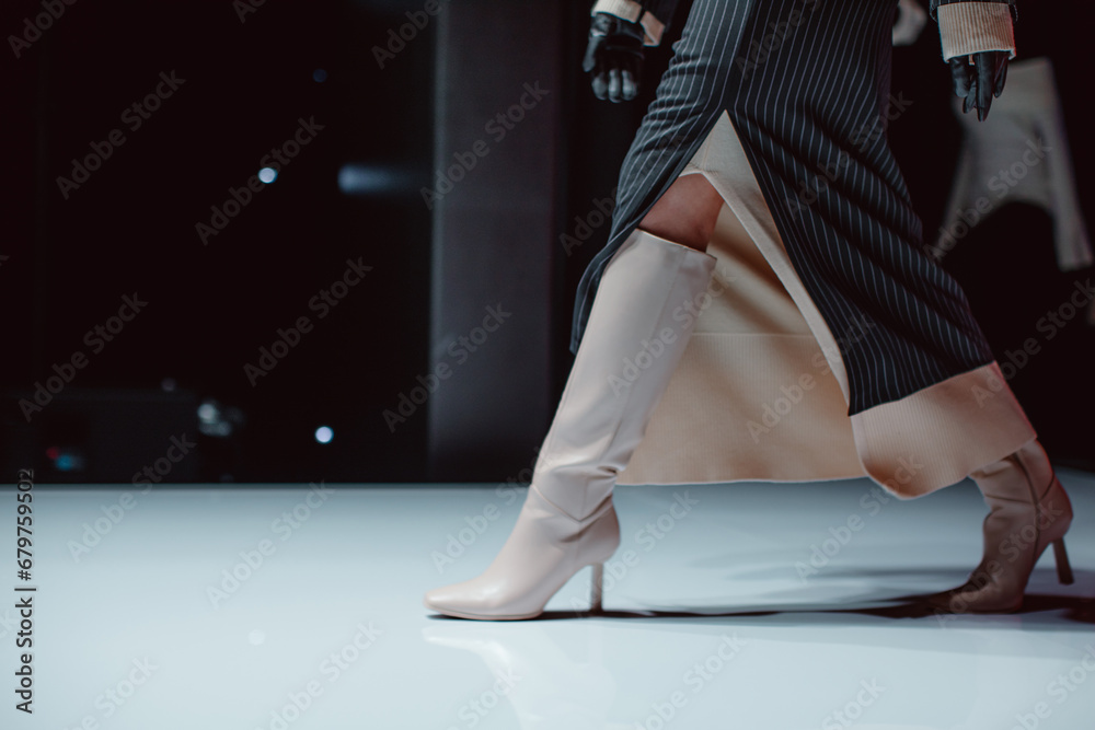 Black long skirt and beige high heels. Fashion model walking runway fashion show - obrazy, fototapety, plakaty 