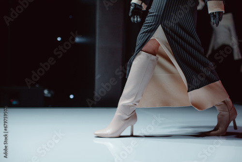 Black long skirt and beige high heels. Fashion model walking runway fashion show photo