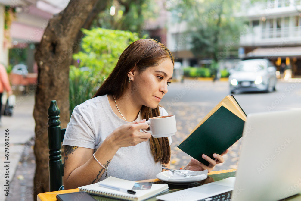 Young woman in a cafe drinking coffee and reading a book. Young woman in a cafe drinking coffee and reading a book.