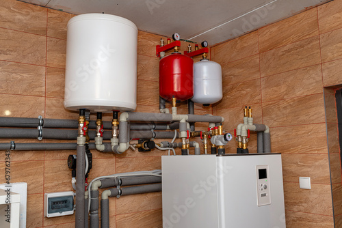 A modern air heat pump installed in the home's boiler room, visible plastic pipes and valves.