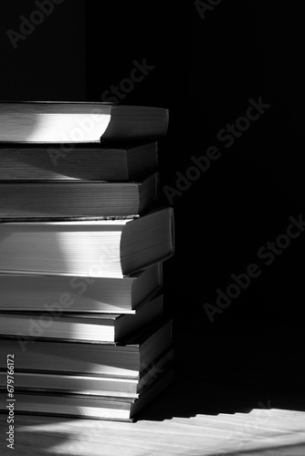 stack of books with abstract shadows in black and white mode
