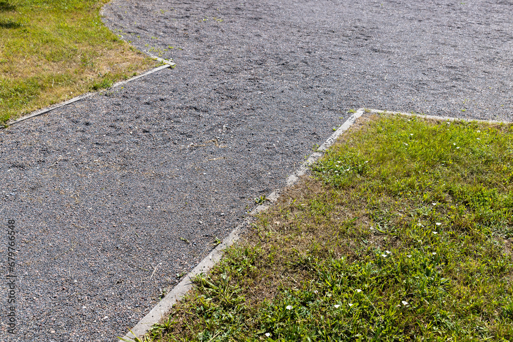 Obraz premium part of a walkway sprinkled with small rubble and stonesecological-style park path for walking