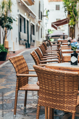 Empty tables at streets of city of Marbella in Costa del Sol, Spain. The Old Town and iconic streets in Marbella, Spain, and major tourist attractions with shops and bars at city centre © manuta