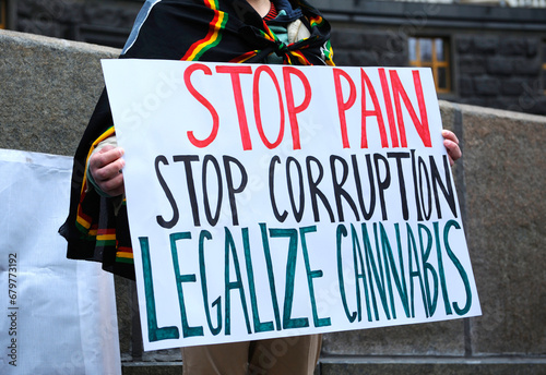 Young people hands holding broadsheet demanding legalization of medical marijuana. Cannabis March.