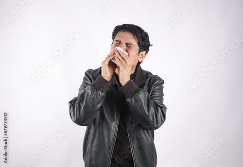 Photograph of person with headache, sneezing, holding toilet paper. Concept of health and diseases. © artrolopzimages