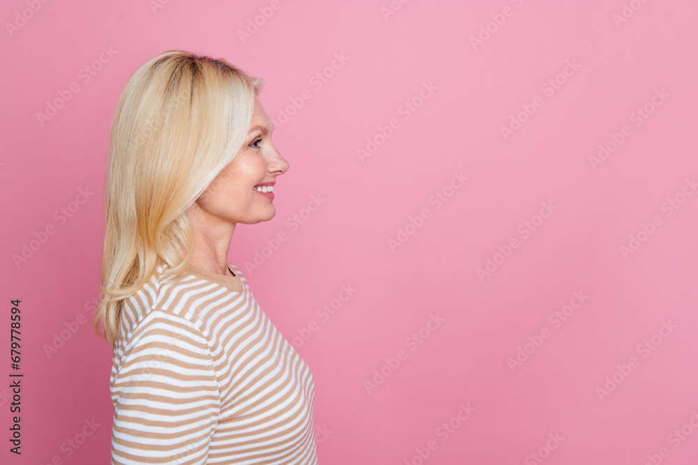 Side profile photo of positive woman with stylish hair wear trendy clothes look at offer empty space isolated on pink color background Side profile photo of positive woman with stylish hair wear trendy clothes look at offer empty space isolated on pink color background