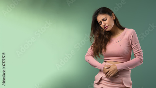 Indian woman wincing in pain and hand rubbing stomach
