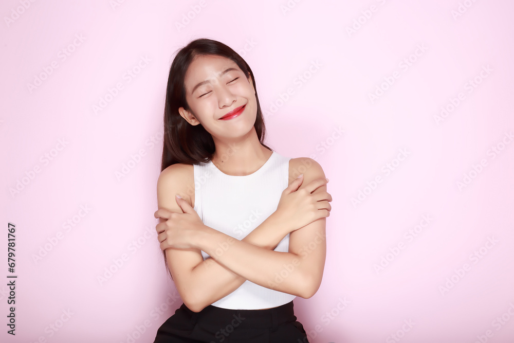 Portrait of a beautiful young woman in a light pink background, half body photo of nice positive lady crossed arms posing empty space ad isolated. Portrait of a beautiful young woman in a light pink background, half body photo of nice positive lady crossed arms posing empty space ad isolated.