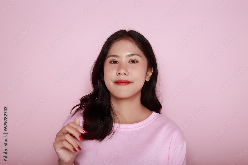 Portrait of a beautiful young woman in a light pink background, happy and smile, posting in stand position, half body photo of nice positive lady, Portrait of a friendly young woman smiling happily. Portrait of a beautiful young woman in a light pink background, happy and smile, posting in stand position, half body photo of nice positive lady, Portrait of a friendly young woman smiling happily.