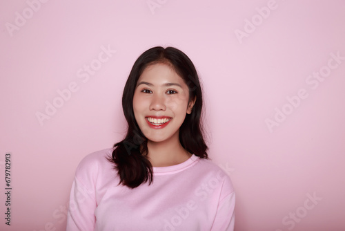half body photo of nice positive lady  Portrait of a beautiful young woman in a light pink background  happy and smile  posting in stand position 