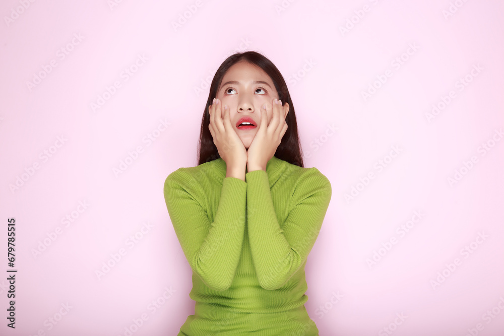 Asian woman making an angry expression, Portrait of a young woman in a light pink background. Asian woman making an angry expression, Portrait of a young woman in a light pink background.