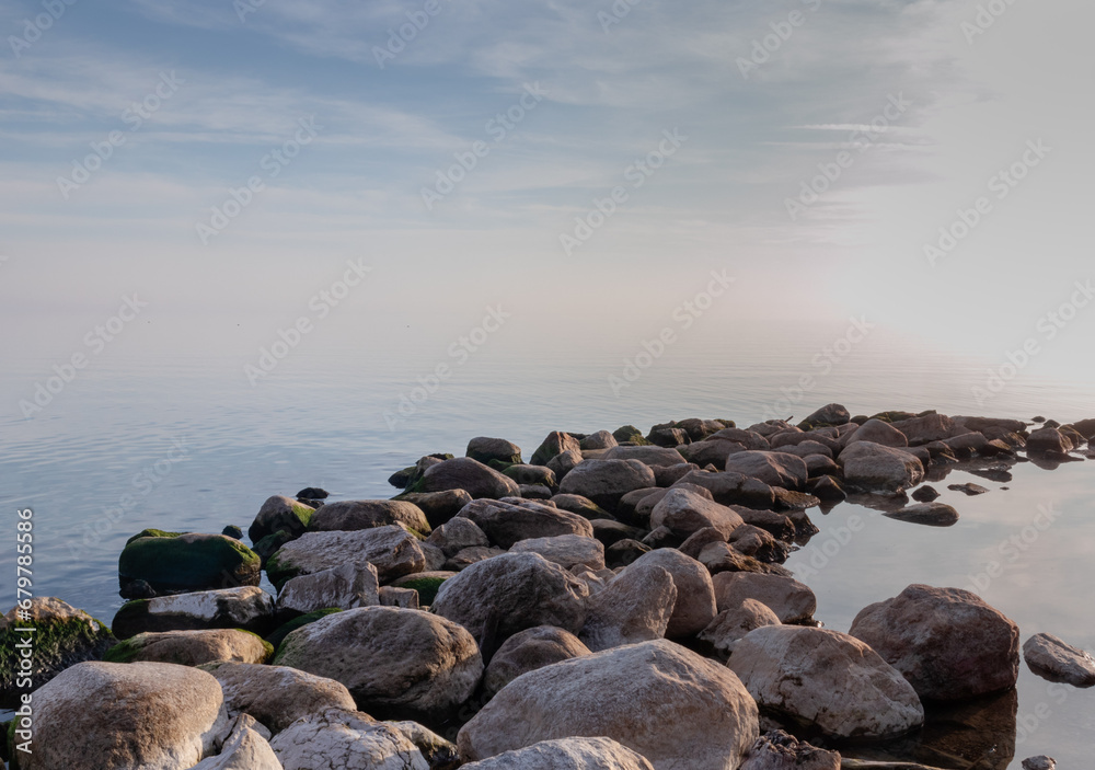 Evening sunlight on the rocks at the shore of Lake Ontario. Tranquil nature background.