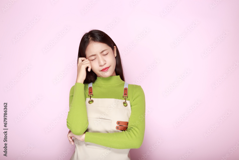 Asian woman making an angry expression, Portrait of a young woman in a light pink background. Asian woman making an angry expression, Portrait of a young woman in a light pink background.
