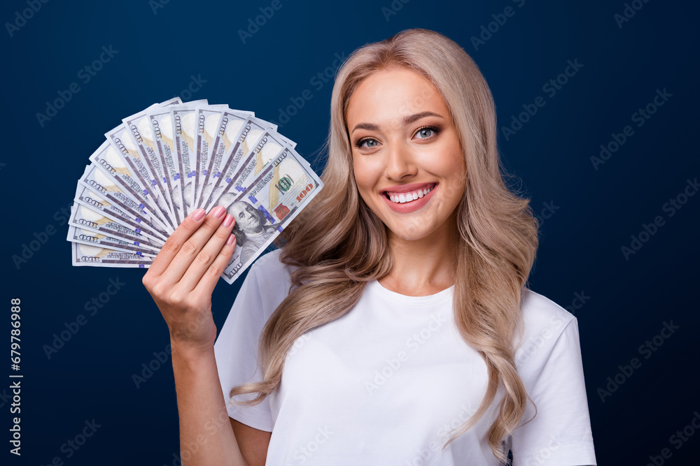 Photo of positive adorable girl wear trendy clothes hand hold money cash going shopping isolated on dark blue color background Photo of positive adorable girl wear trendy clothes hand hold money cash going shopping isolated on dark blue color background
