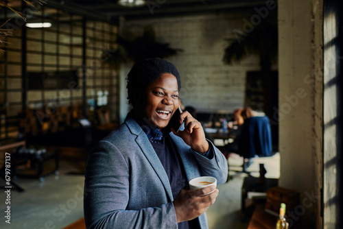 Young businessman having phone call on coffee break in office