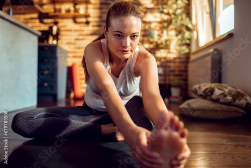 Beautiful woman at peace doing yoga on living room floor