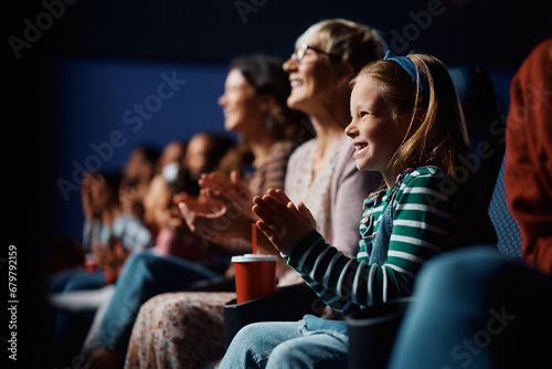 Happy girl applauding after movie projection in cinema. photo