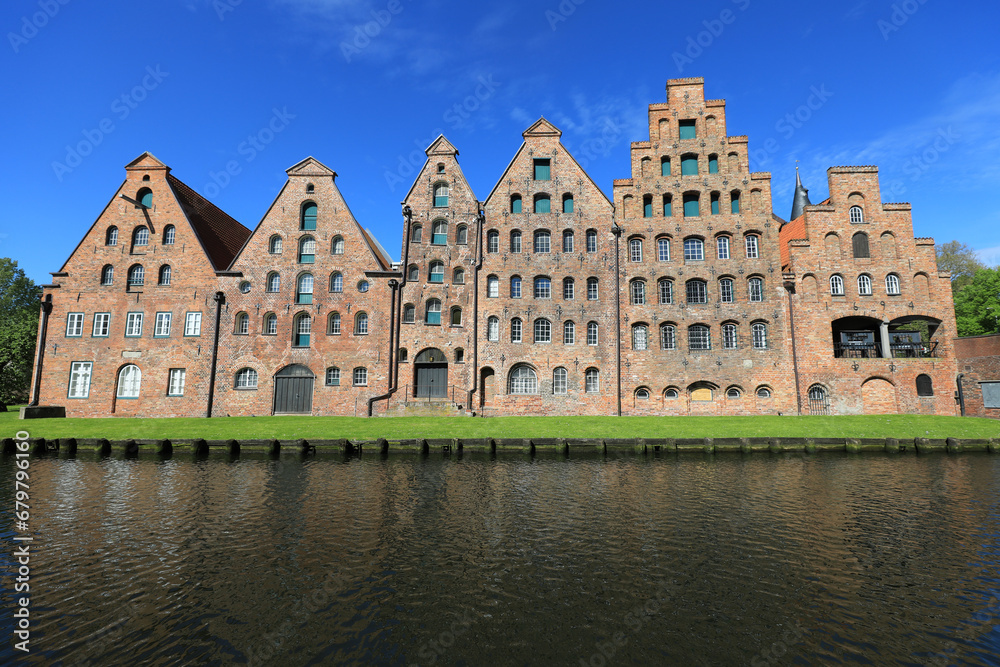 Φωτογραφία Historische Speicherhäuser am Traveufer in Lübeck unter klarem, blauem Himmel