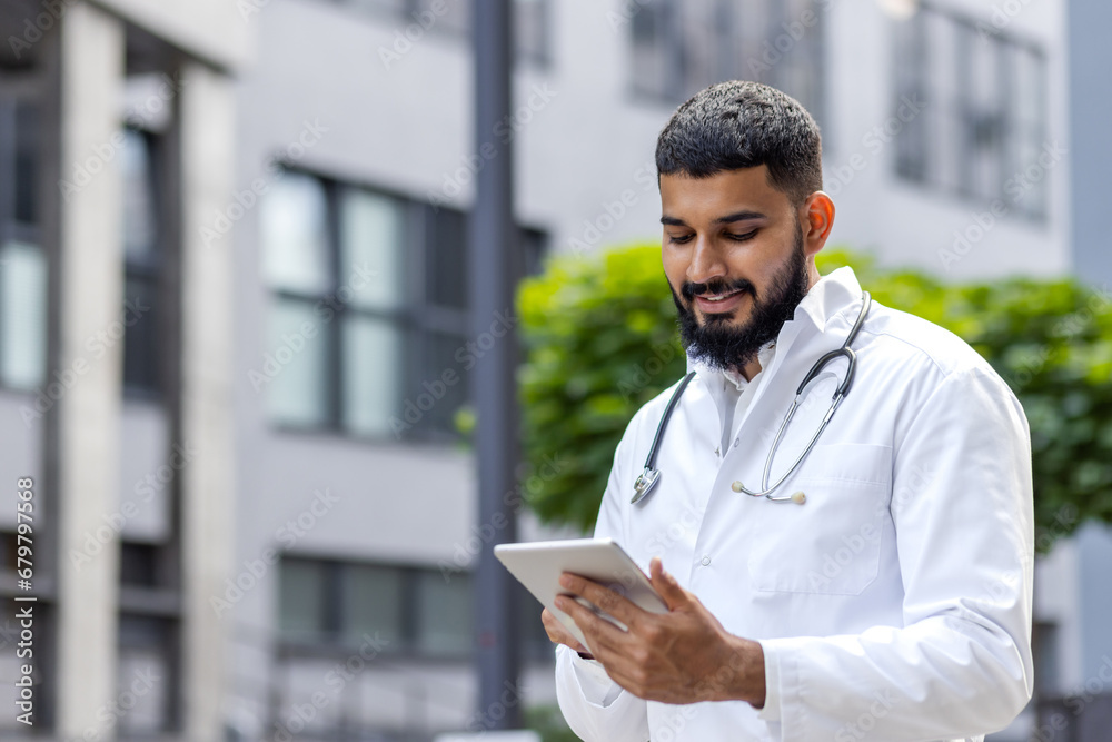 Ταπετσαρία A young Muslim doctor in a bedlam robe stands outside the hospital and uses a ta