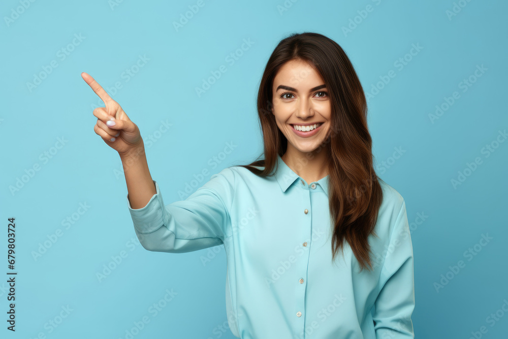 Happy young woman pointing with finger at copy space isolated on blue background Happy young woman pointing with finger at copy space isolated on blue background