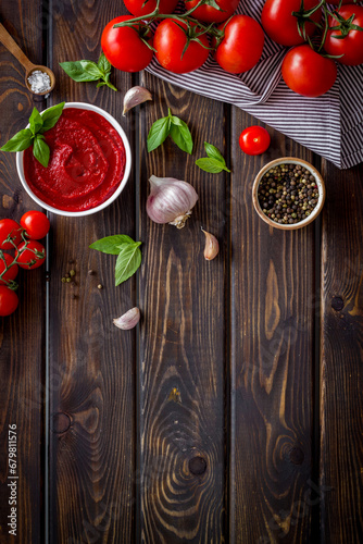 Tomato sauce passata in bowl with fresh tomatoes and basil