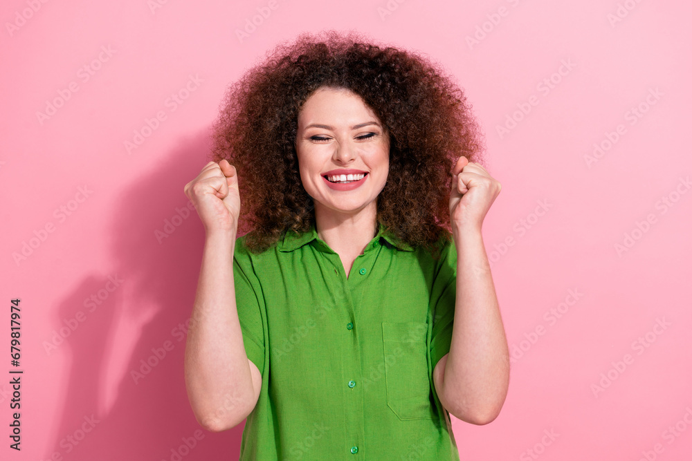 Photo of funky excited young lady wear green shirt screaming yeah rising fists closed eyes isolated pink color background Photo of funky excited young lady wear green shirt screaming yeah rising fists closed eyes isolated pink color background