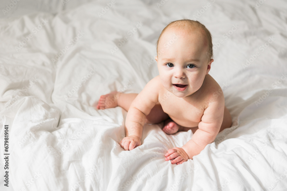 Adorable baby boy in white sunny bedroom. Newborn child relaxing in bed copy space mockup. Nursery for young children. Textile and bedding for kids. Family morning at home. Adorable baby boy in white sunny bedroom. Newborn child relaxing in bed copy space mockup. Nursery for young children. Textile and bedding for kids. Family morning at home.