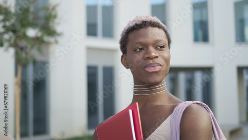 Content queer black man with folder on street