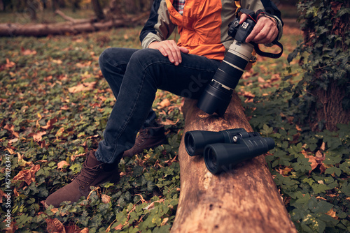 Man using binoculars and camera for bird and animal watching in nature. photo