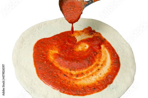 pizza dough with tomato paste applied with kitchen ladle, isolated on white background