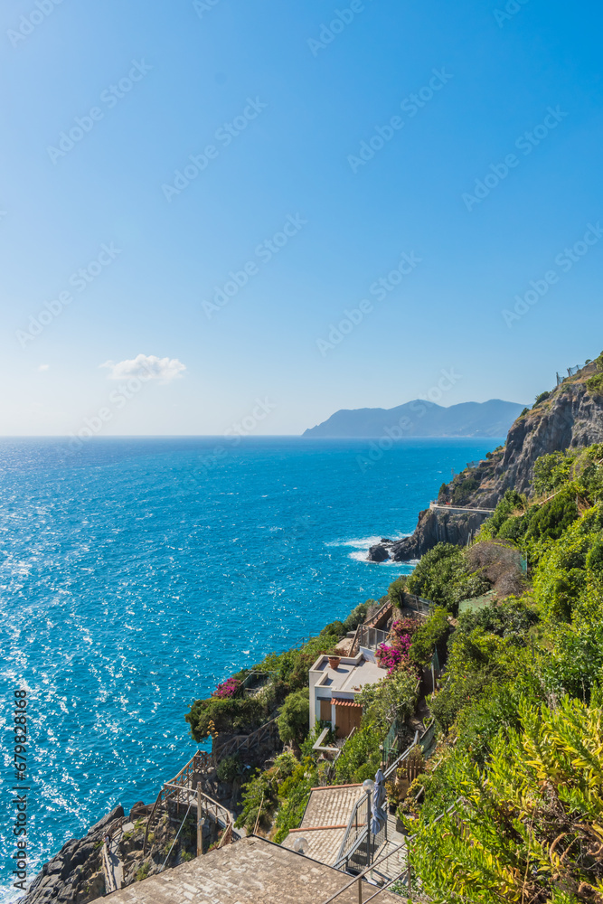 Viewpoint on cliff with vegetation and mountain trails next to the turquoise Mediterranean sea, Riomaggiore ITALY